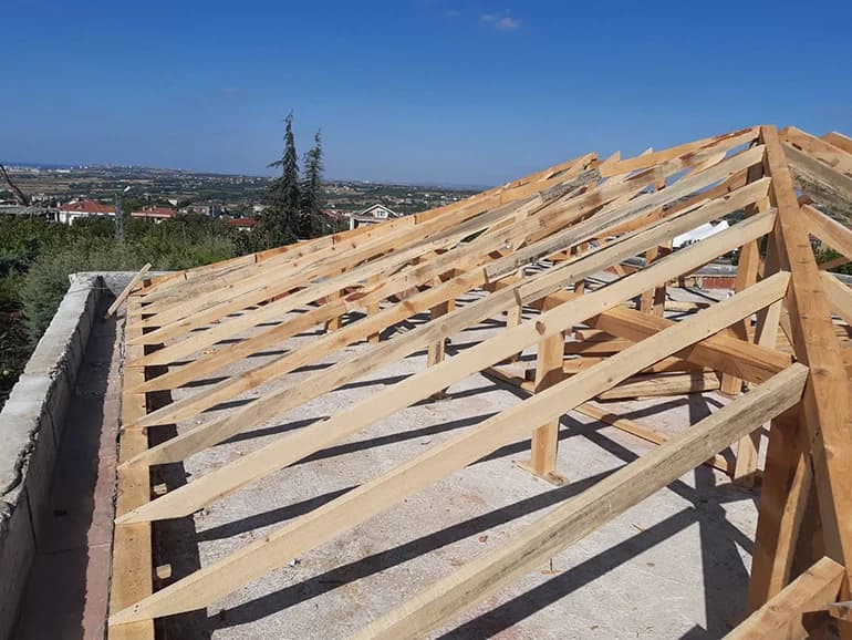 Ahşap çatı konstrüksiyonu üzerinde çalışan çatı ustası